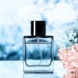 front-view-elegant-perfume-colored-flowers-light-blue-background-with-free-space