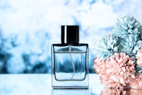 front-view-elegant-perfume-colored-flowers-light-blue-background-with-free-space